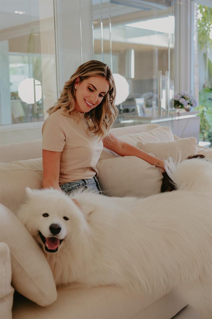Dra. Andrea no sofá com os cachorros
